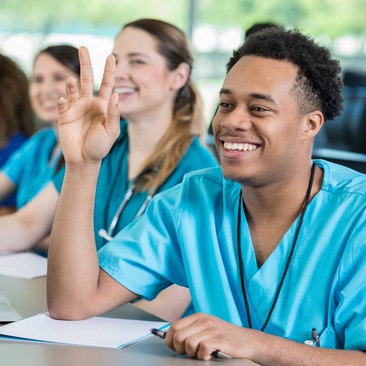 Group of nurses in blue scrubs attentively attending medical classes.